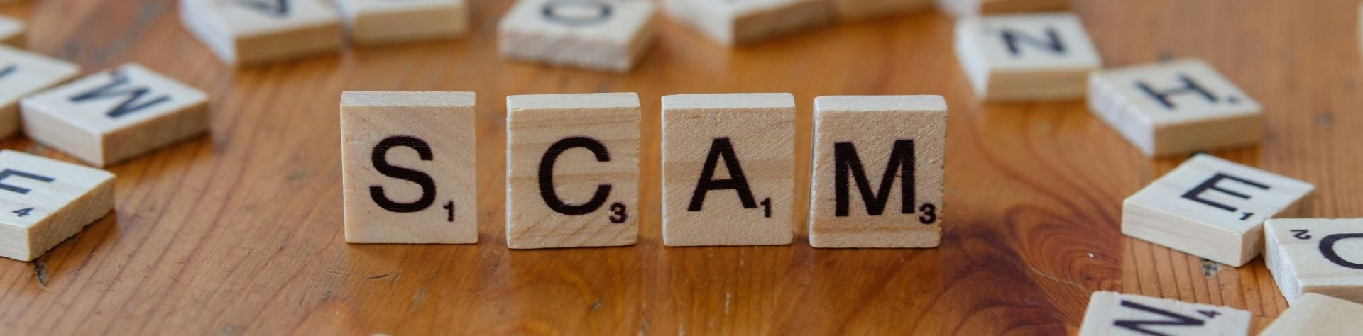 scrabble letters spelling out the word scam
